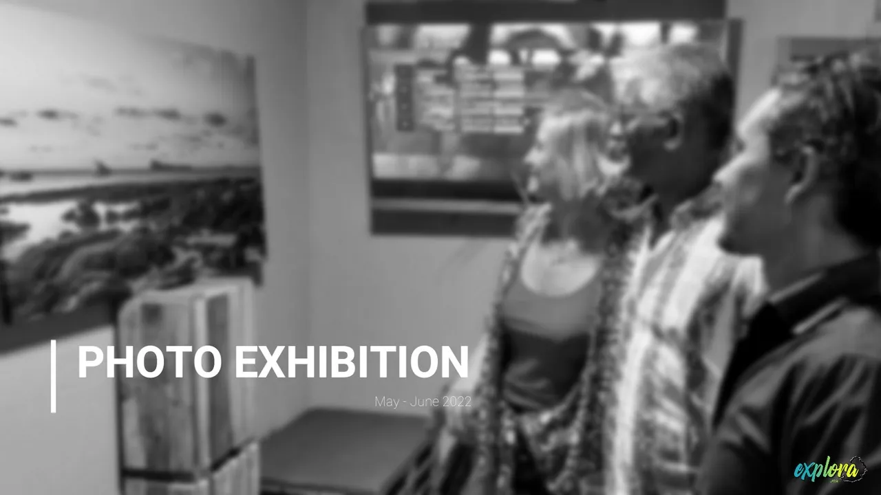Kurt François explaining an Explora photo exhibition canvas print to two visitors in Mauritius