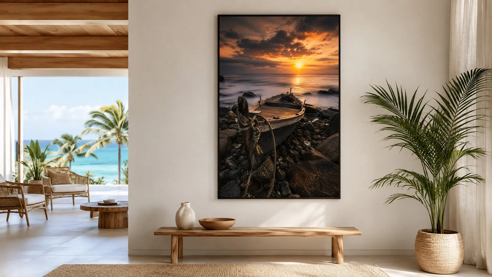 Large framed photo print of a wooden boat on a rocky Mauritius shore at sunset displayed in a bright tropical home interior