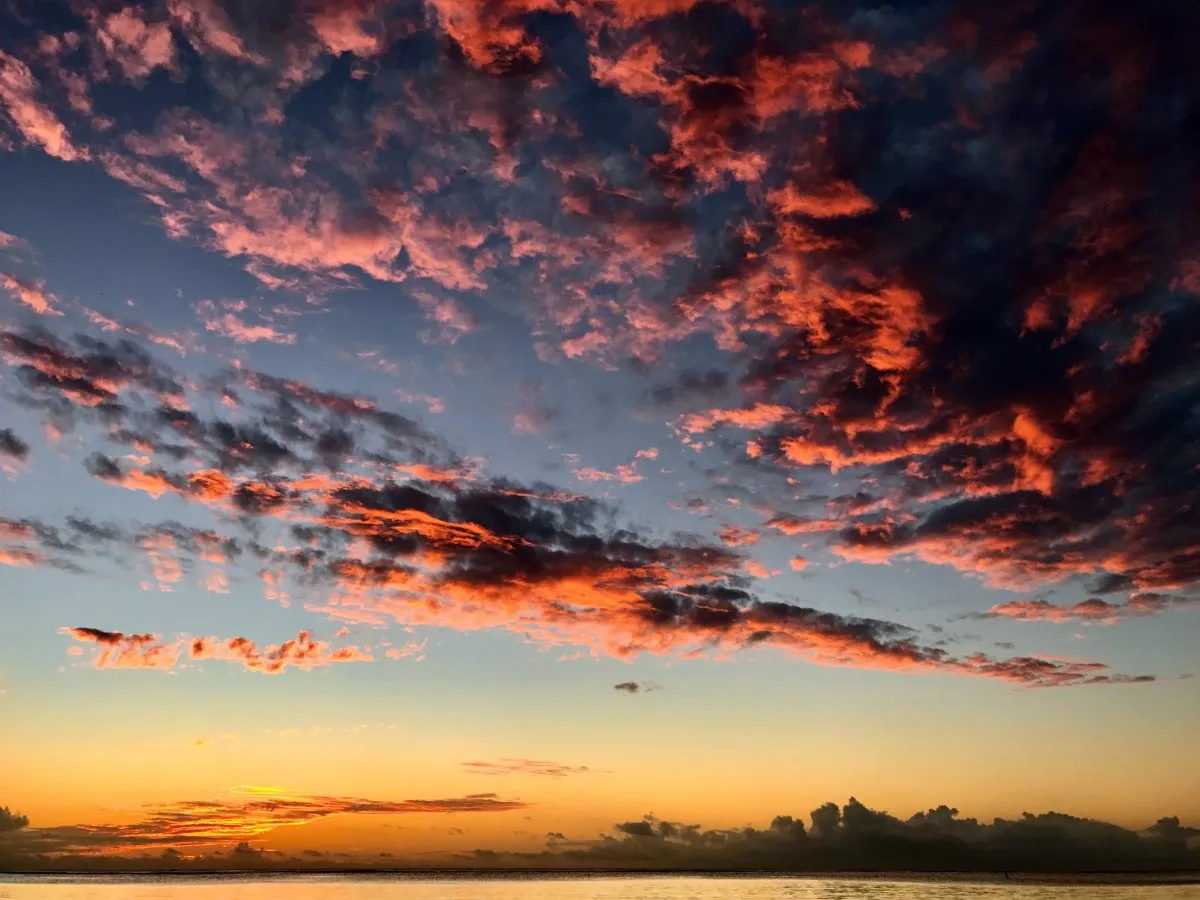 Reddish and purple sunset clouds over Balaclava Beach in Mauritius