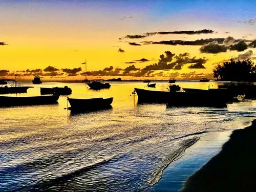 Yellow sunset & boats silhouettes at Mont Choisy beach