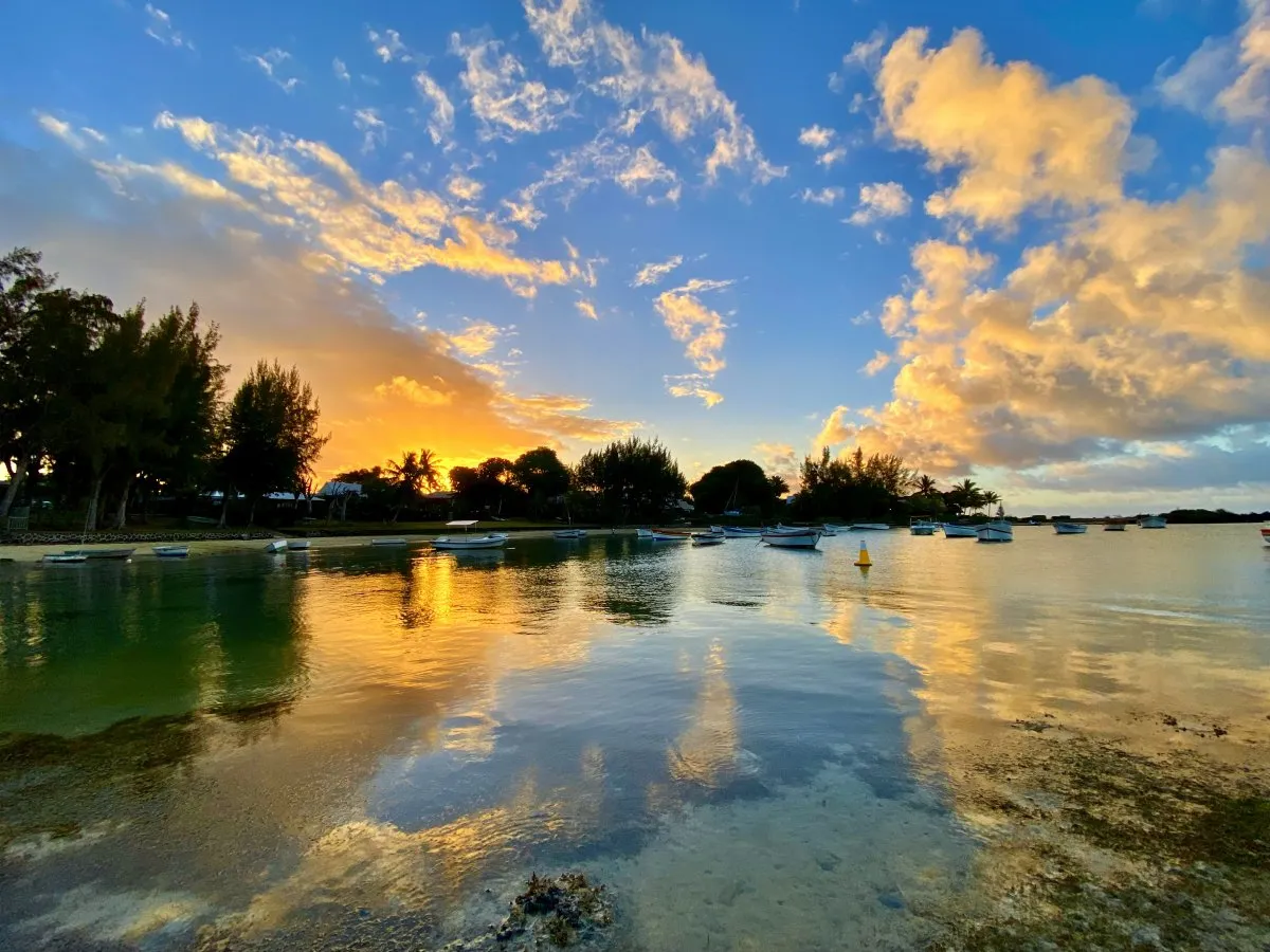 Calm sea water reflecting clouds at Cap Malheureux beach lagoon in Mauritius at sunset