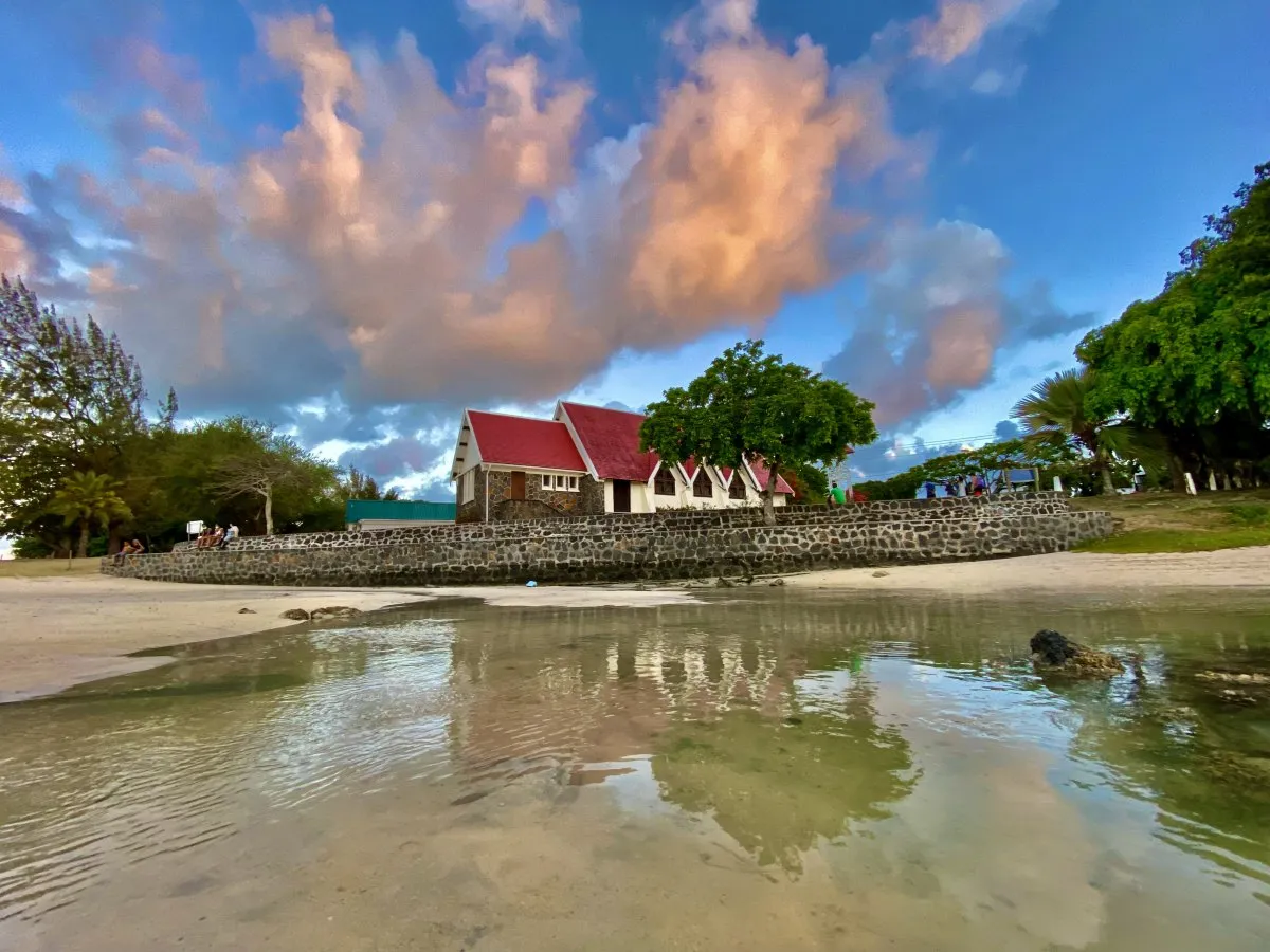 Notre-Dame Auxiliatrice church with red roof by Cap Malheureux beach in northern Mauritius under cloudy sky