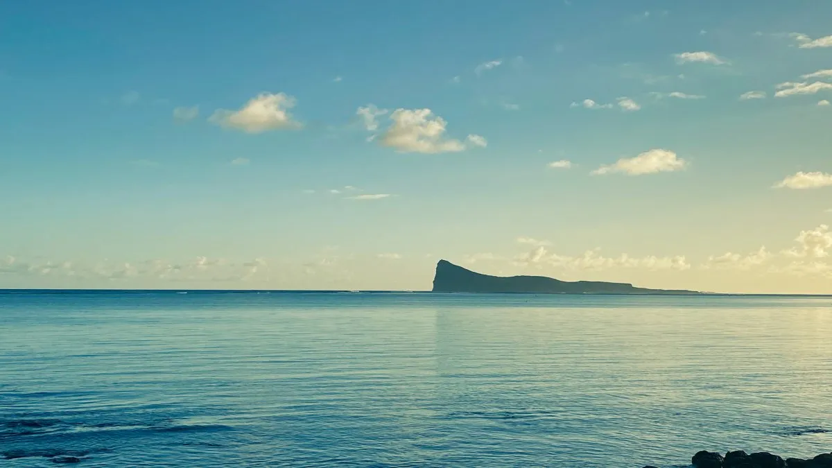Calm ocean and dark blue lagoon at dawn near Coin de Mire in Mauritius