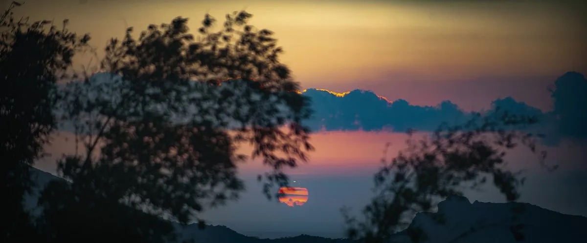 Mountain sunset with clouds passing in front, showcasing beautiful weather in Mauritius