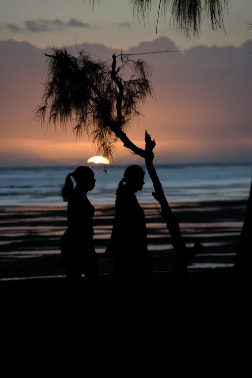 Silhouettes of Mauritian women walking on beach during Sunset