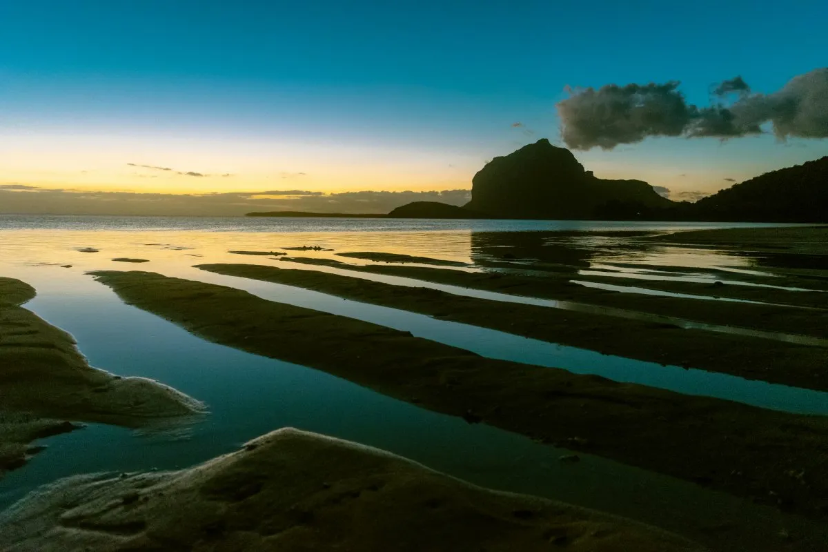 Low tide with sand dunes and water at La Prairie beach during dusk in Mauritius