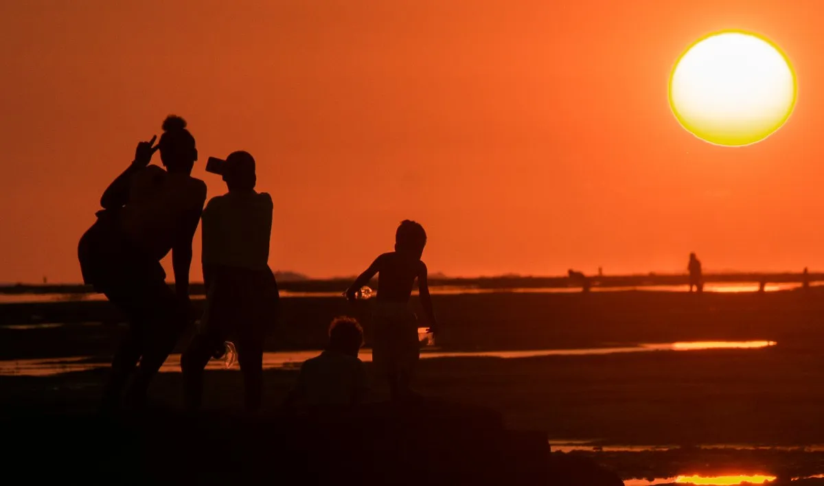 Silhouettes of children playing on the beach during sunset at Riambel in Mauritius
