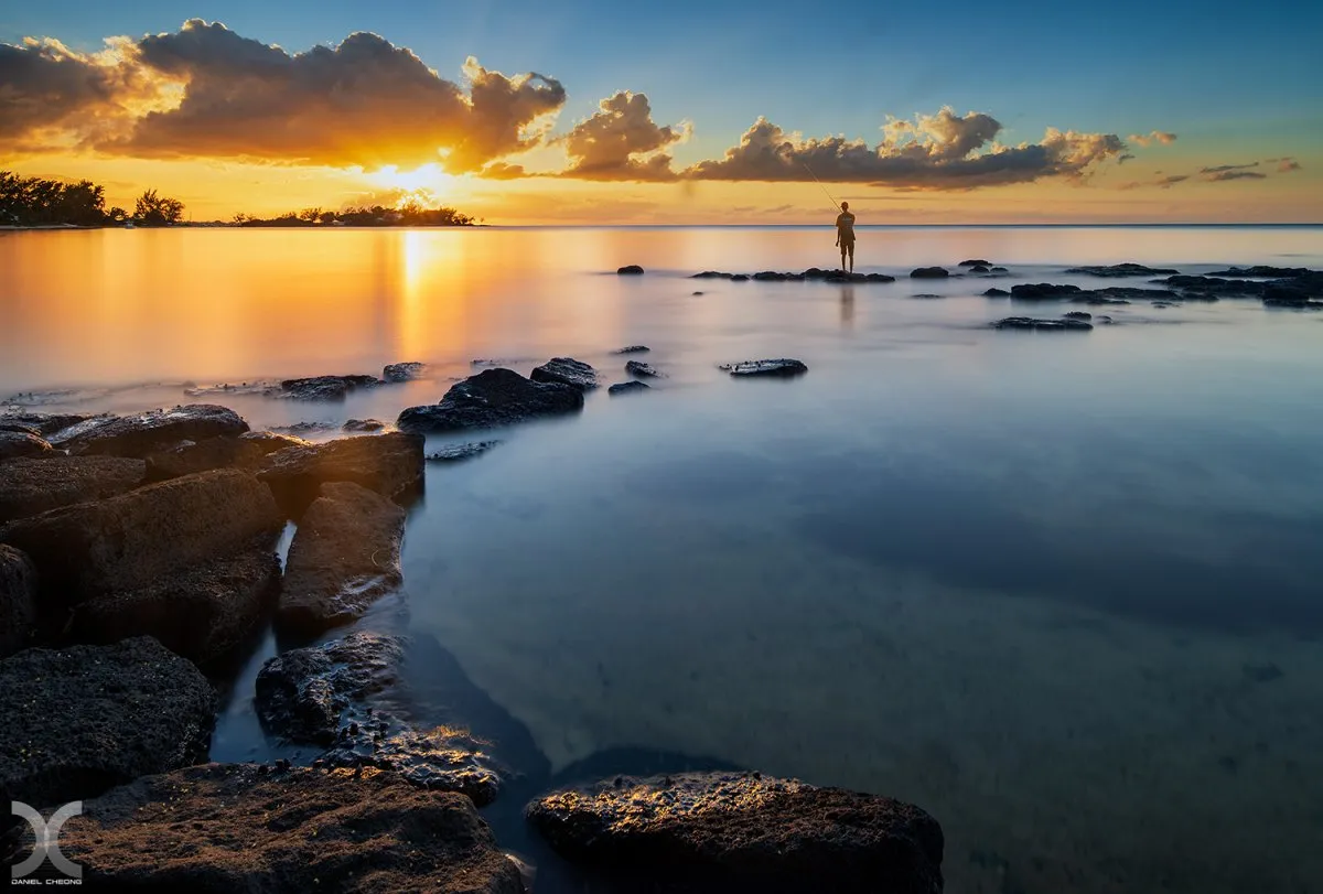 Long exposure seascape of Grand Bay lagoon at sunset in Mauritius with calm water and dramatic sky