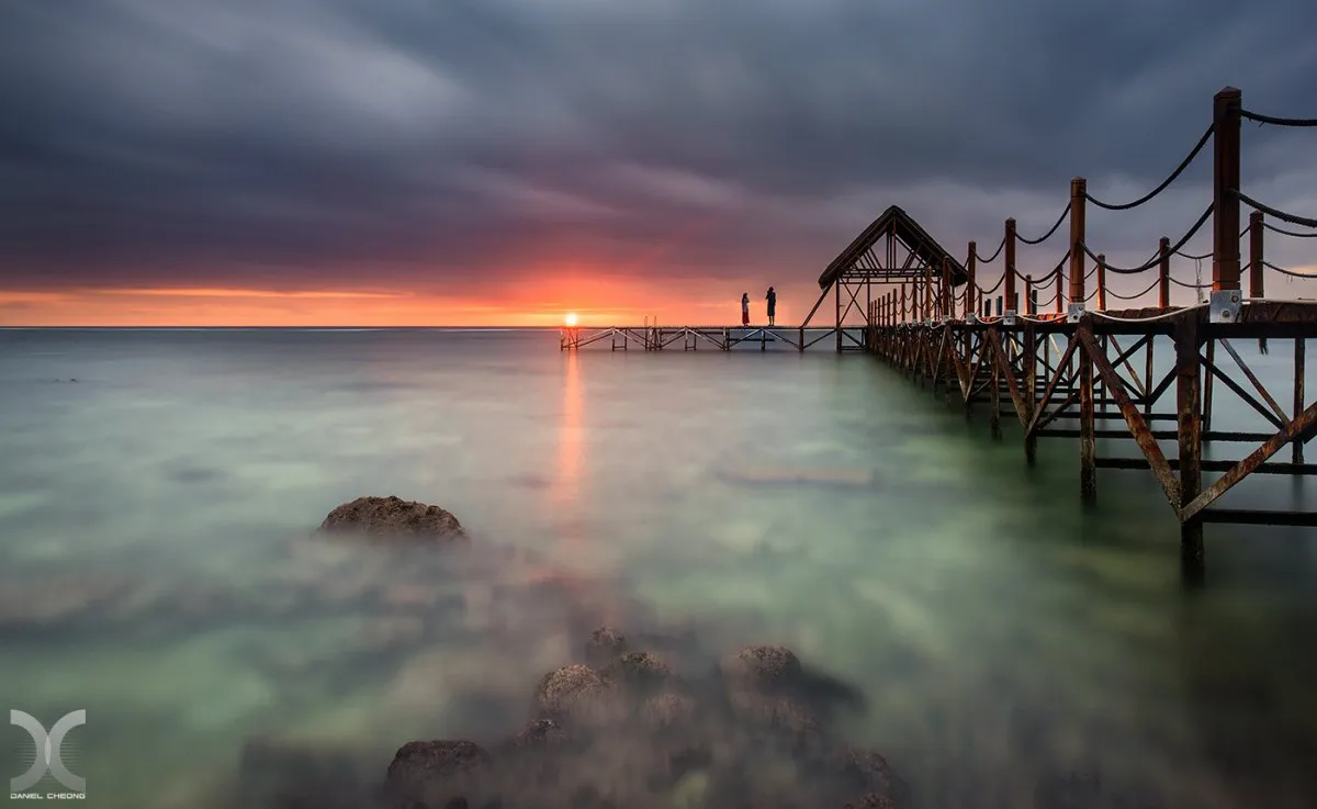 Dark grey clouds over the lagoon and wooden jetty at Pointe Aux Piments in Mauritius