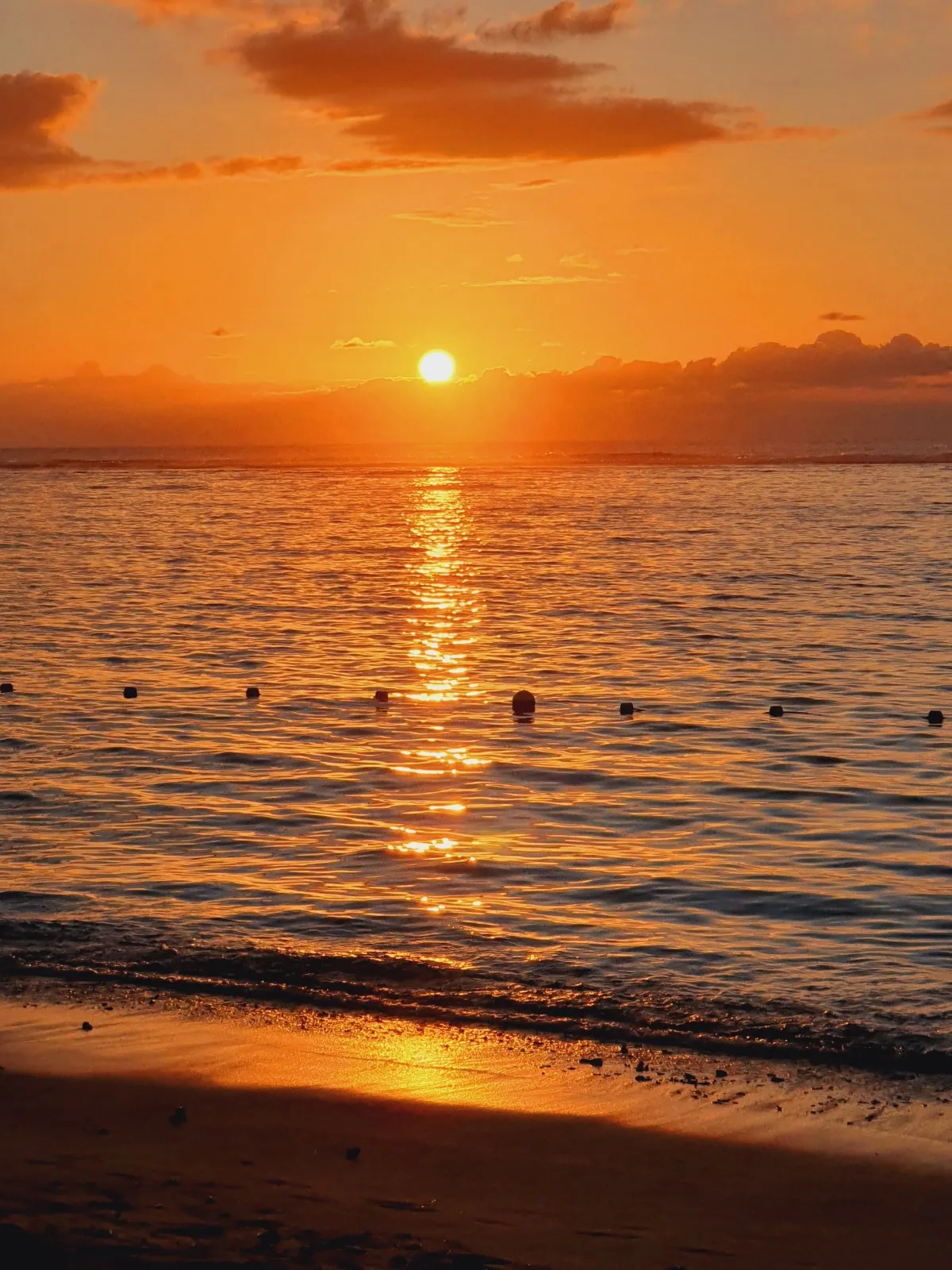 Sunset reflecting on the ocean at Flic En Flac beach in Mauritius with calm waters and colorful skies