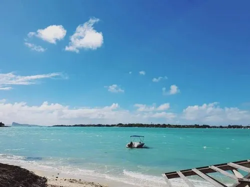 Trou aux Biches beach with boat in turquoise lagoon