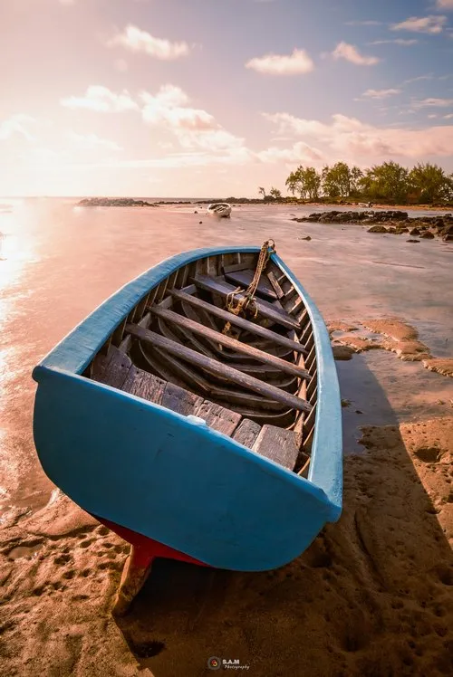 Blue pirogue during low tide at Grand Gaube