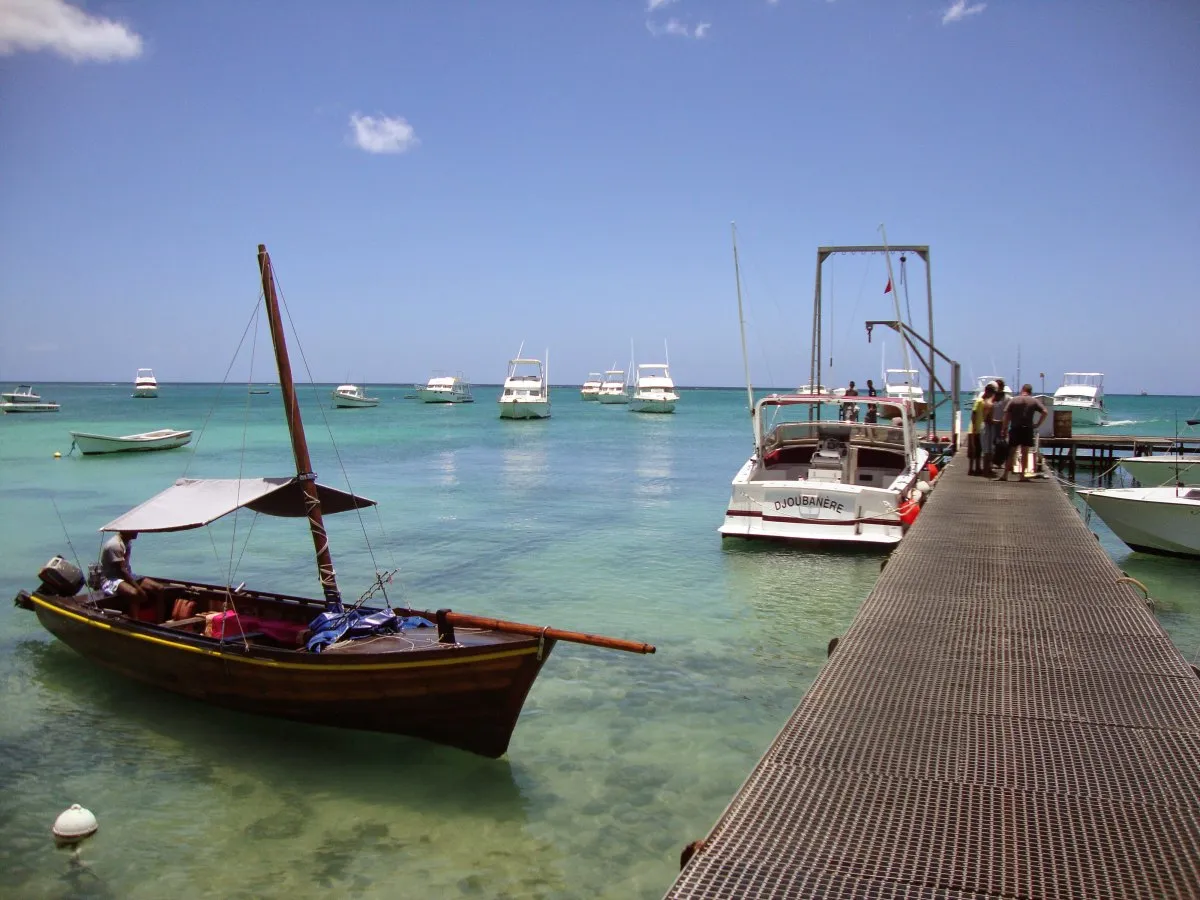 Boats docked near the fishing jetty at Mont Choisy in Mauritius with fishermen unloading catch