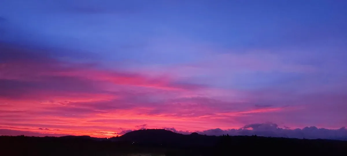 Red-sky sunset with mountain silhouettes and dramatic clouds over Mauritius