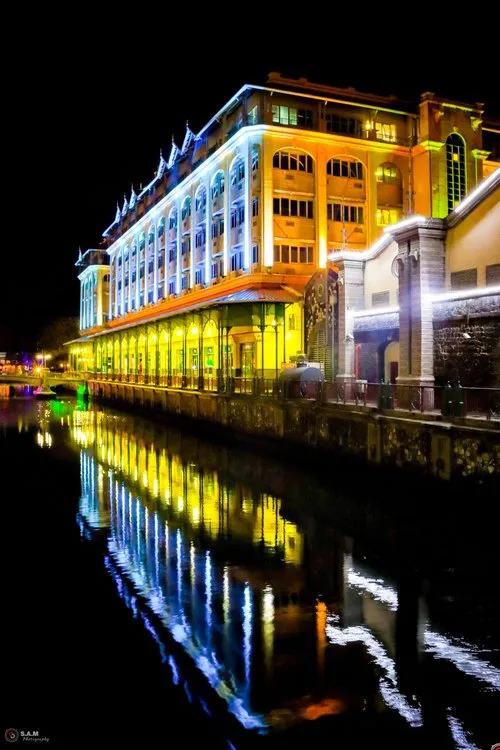 Reflection in canal of illuminated Caudan Waterfront building