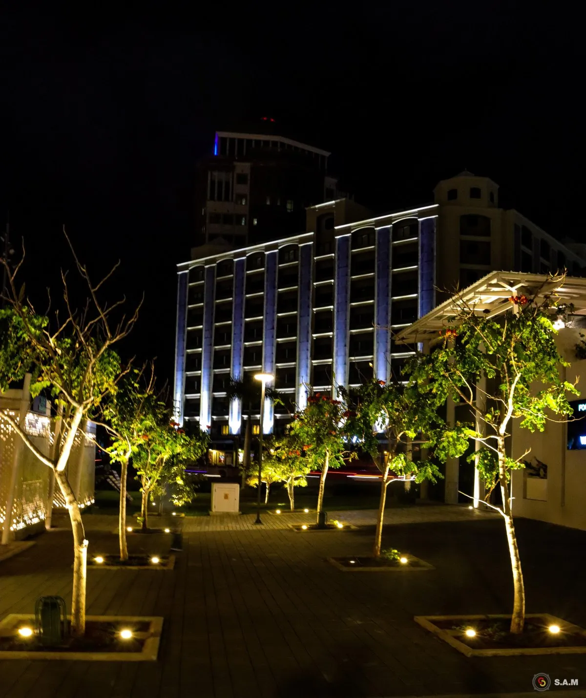 View of harbor front building near Caudan waterfront in Port Louis, Mauritius with surrounding trees and architecture