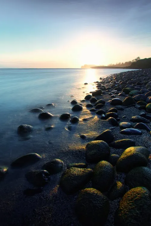 Large polished black pebbles on seashore of Rivière des Galets