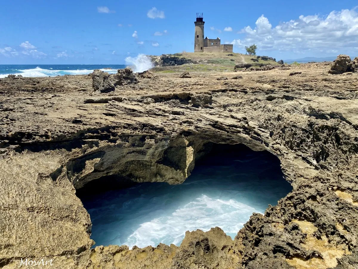 Sea cave and lighthouse ruins on the volcanic rock of Fouquets Island in Mauritius