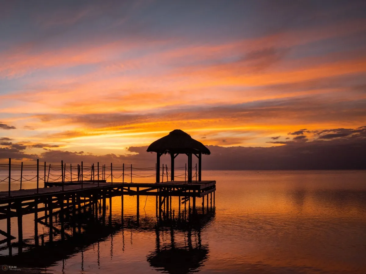 Jetty at Flic en Flac beach with orange clouds during sunset in Mauritius