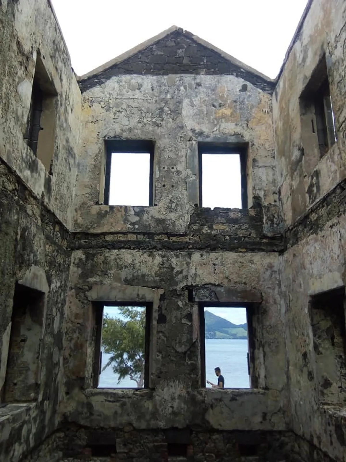 Interior view of old lighthouse ruins with ocean seen through windows on Ile aux Fouquets, Mauritius
