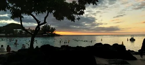 People swimming during sunset at Pereybere beach