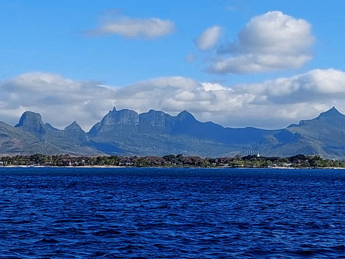 View of Moka mountain range and Le Pouce peak from the sea in Mauritius with lush greenery