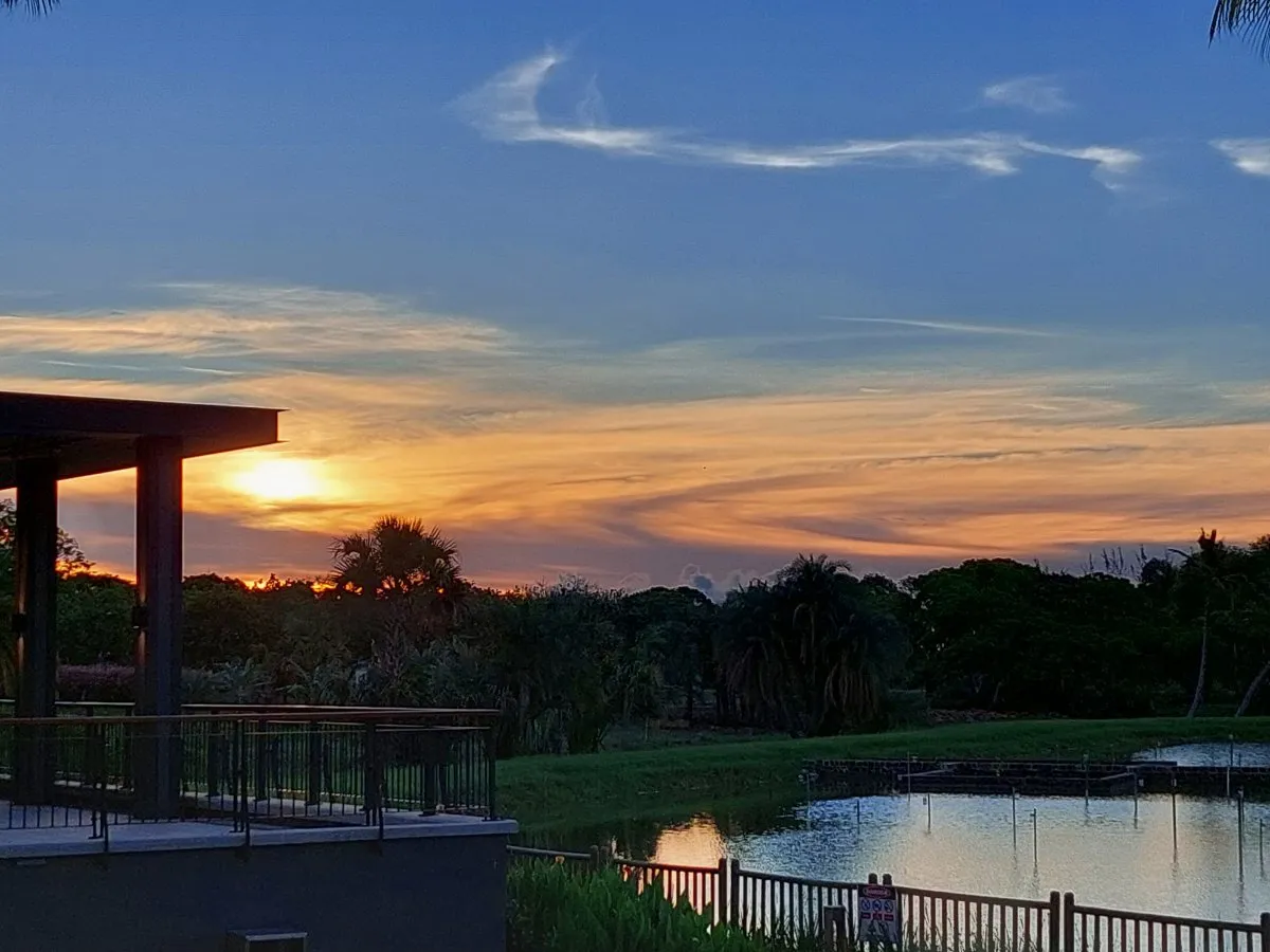Sunset view over Mahogany Lake promenade in Beau Plan, Mauritius with vibrant skies and calm water