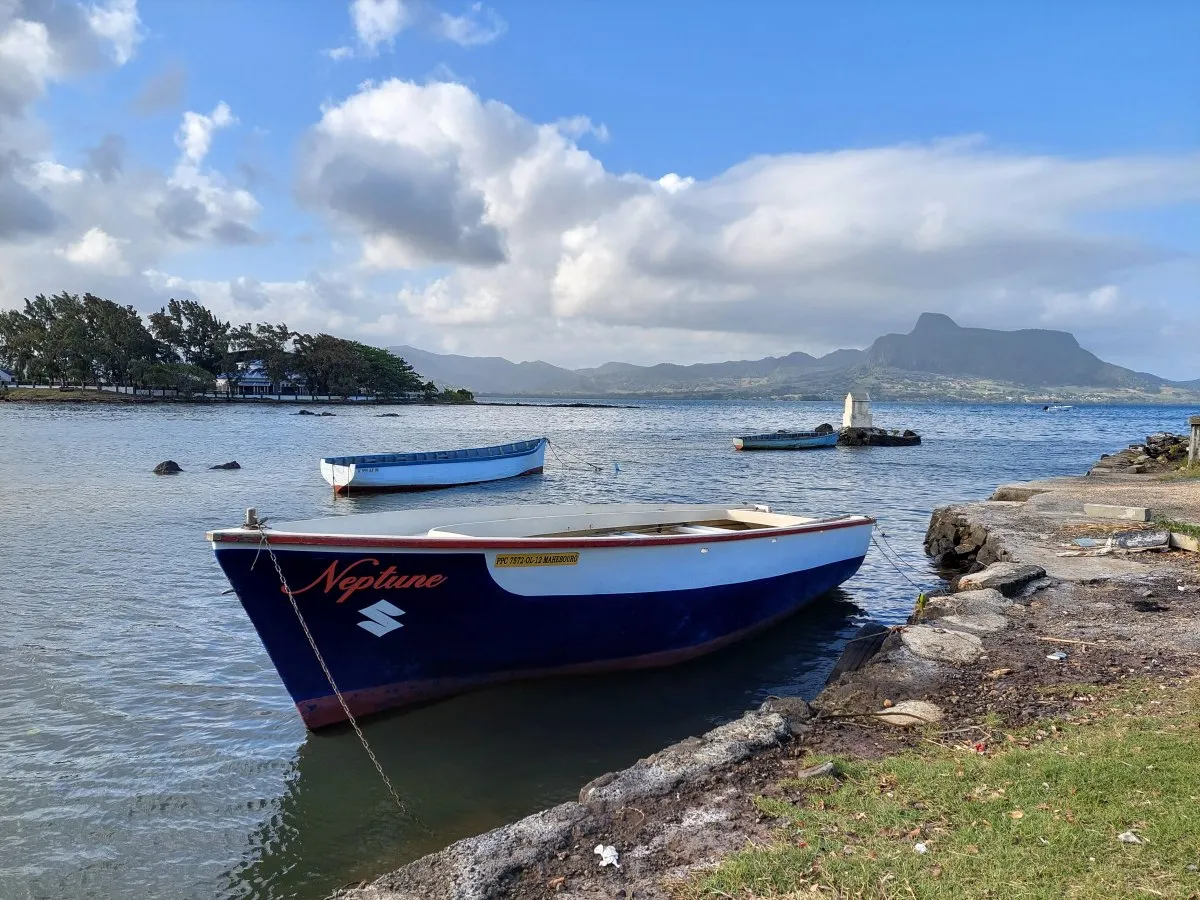 Fishing boat in lagoon at Pointe Canon with Lion Mountain in the background, Mahebourg Mauritius