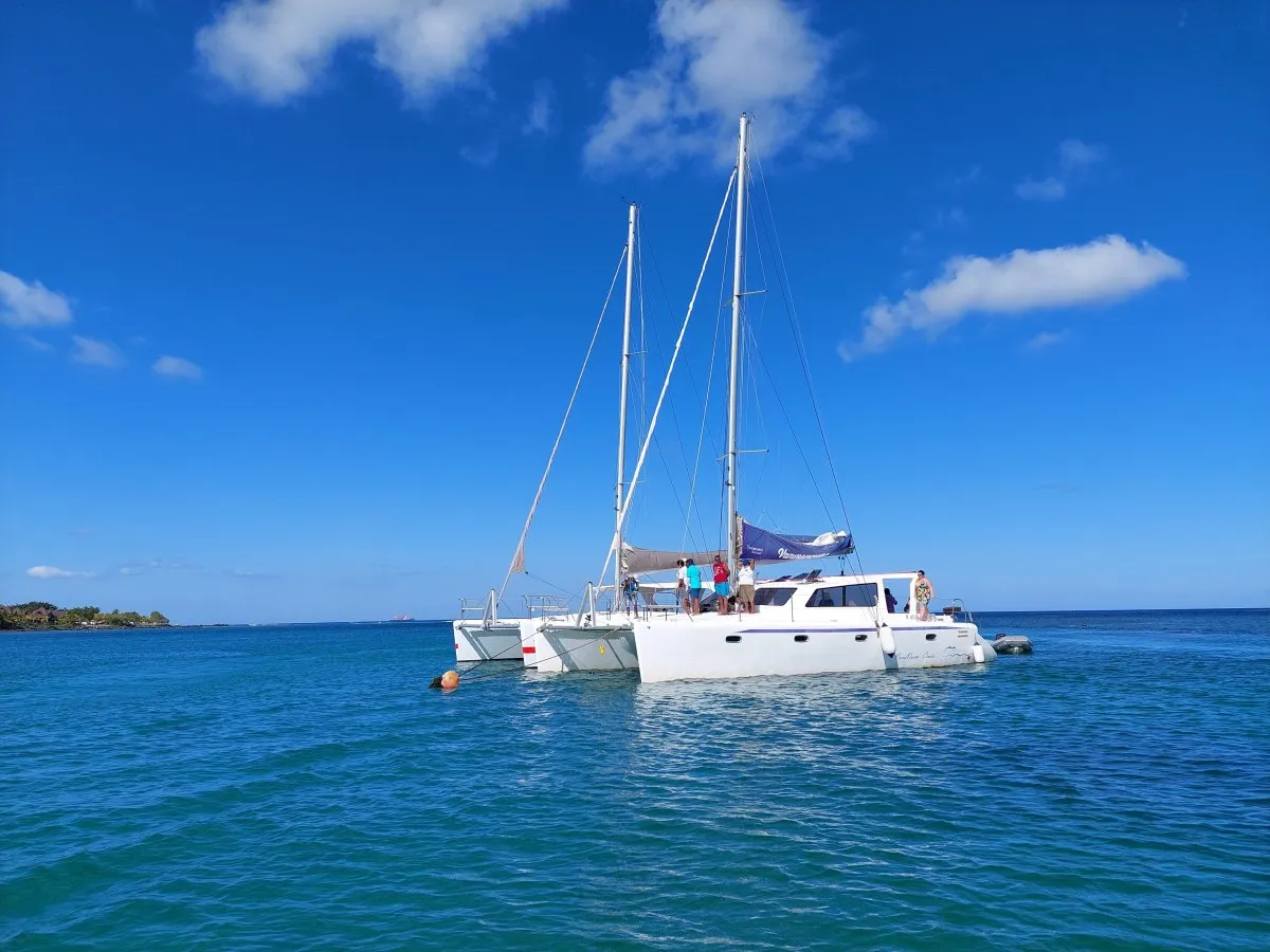 Trimaran boat with people onboard in the calm lagoon of Flat Island in Mauritius