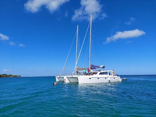 Trimaran with people onboard in lagoon of Flat island