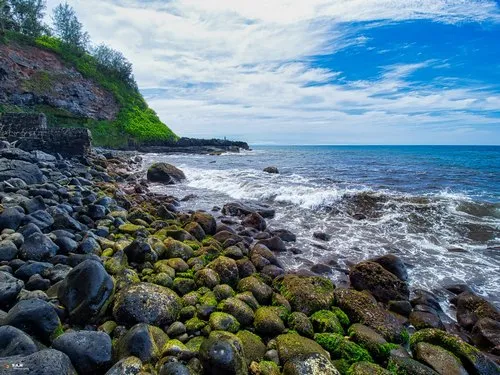 Green round pebbles on the shore at Gris Gris