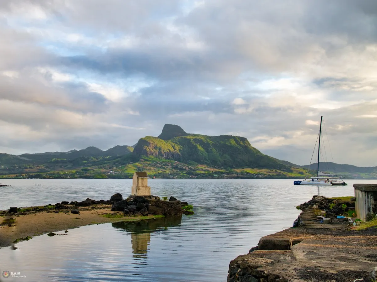 White catamaran sailing in Mahebourg lagoon with Lion mountain in the background in Mauritius