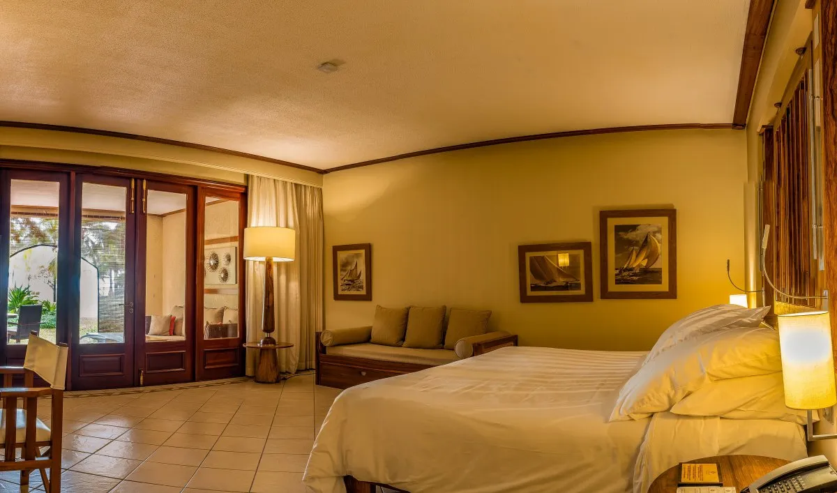 Luxurious hotel room with large bed and garden view at Le Paradis Beachcomber in Mauritius