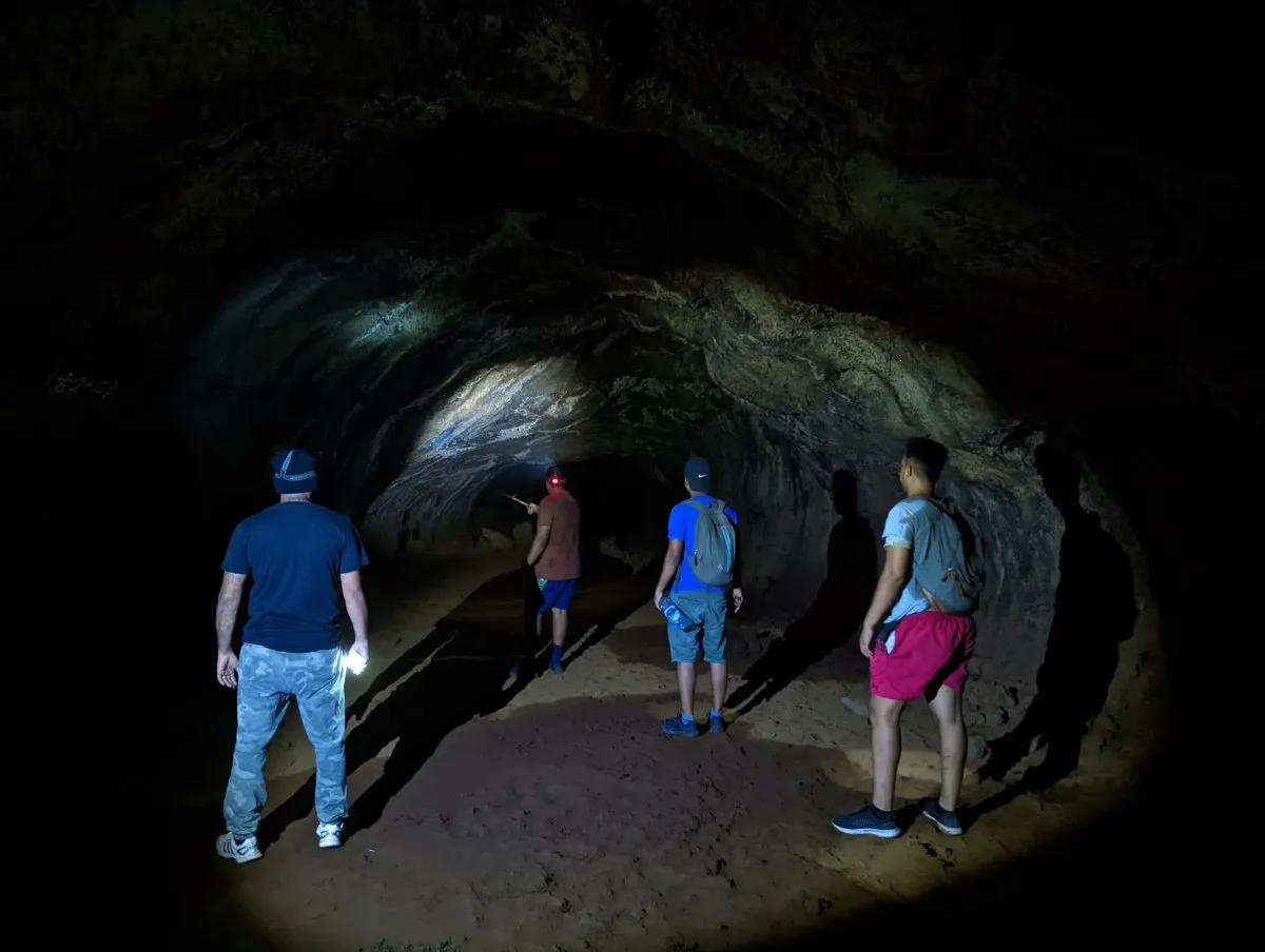 Hikers exploring a hidden cave in Flacq, Mauritius surrounded by rocky terrain
