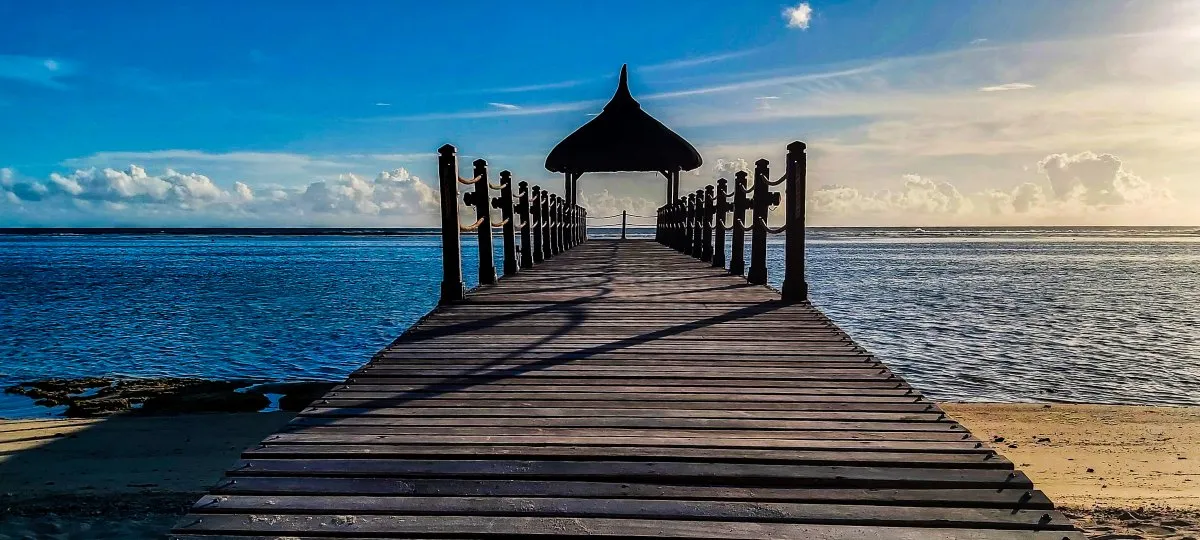 Panoramic view of Shanti Maurice beach jetty surrounded by blue sea and tropical garden in Mauritius