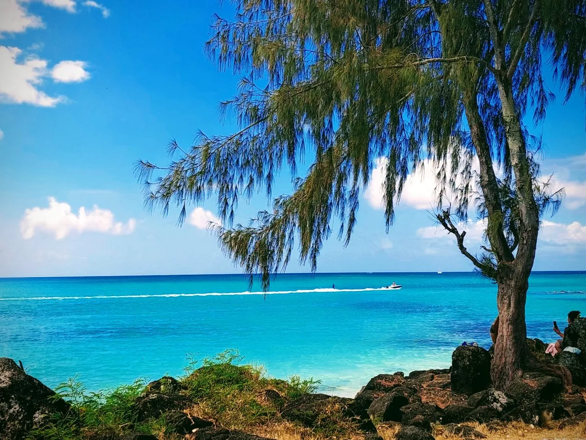 Speed boat cruising in the turquoise lagoon at La Cuvette public beach in Mauritius near Grand Bay