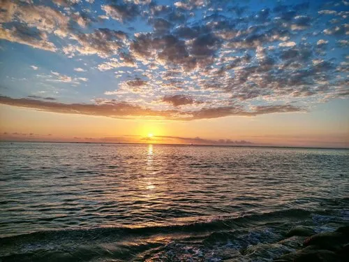 Splendid sunset behind the clouds at Mon Choisy beach