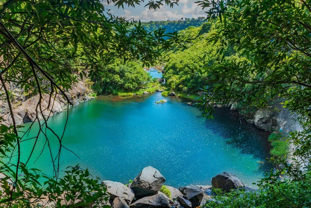 Aerial view of the turquoise lake and surrounding forest at Tamarind Falls in Mauritius