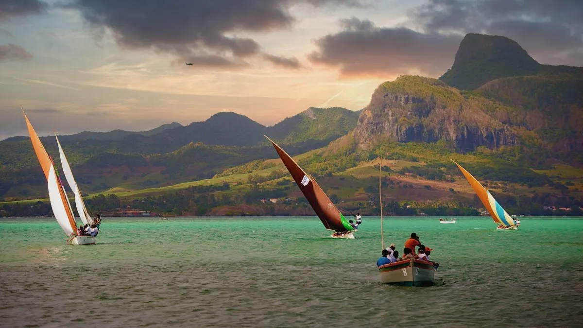 Colorful boats racing during the Regatta at Pointe des Regates with mountains in Mauritius