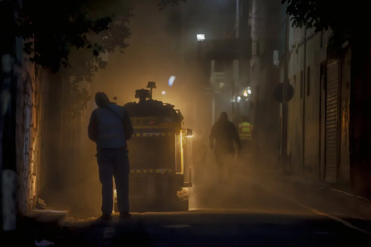 Men working on road construction at night in an alley of Port Louis, Mauritius with yellow lighting