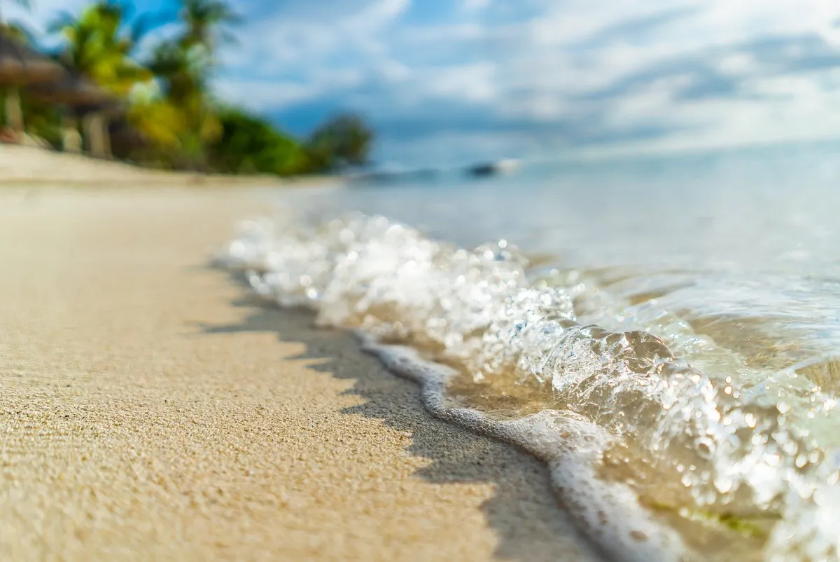 Sparkling sea foam on the beach shoreline at the south coast of Mauritius near Le Paradis Hotel