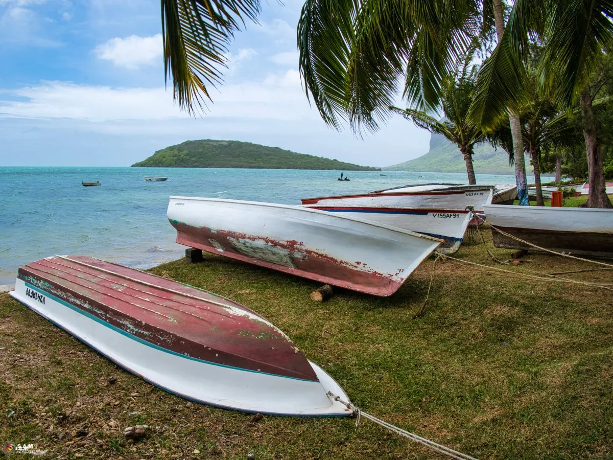 Fisherman’s pirogue pulled out of the sea and tied to trees at Bel Ombre beach in Mauritius before a cyclone