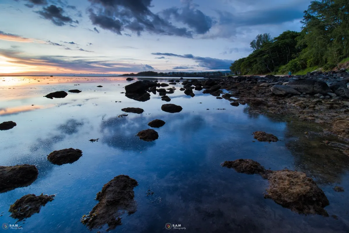 Reflection of clouds on the calm lagoon at Souillac beach in Mauritius at sunset