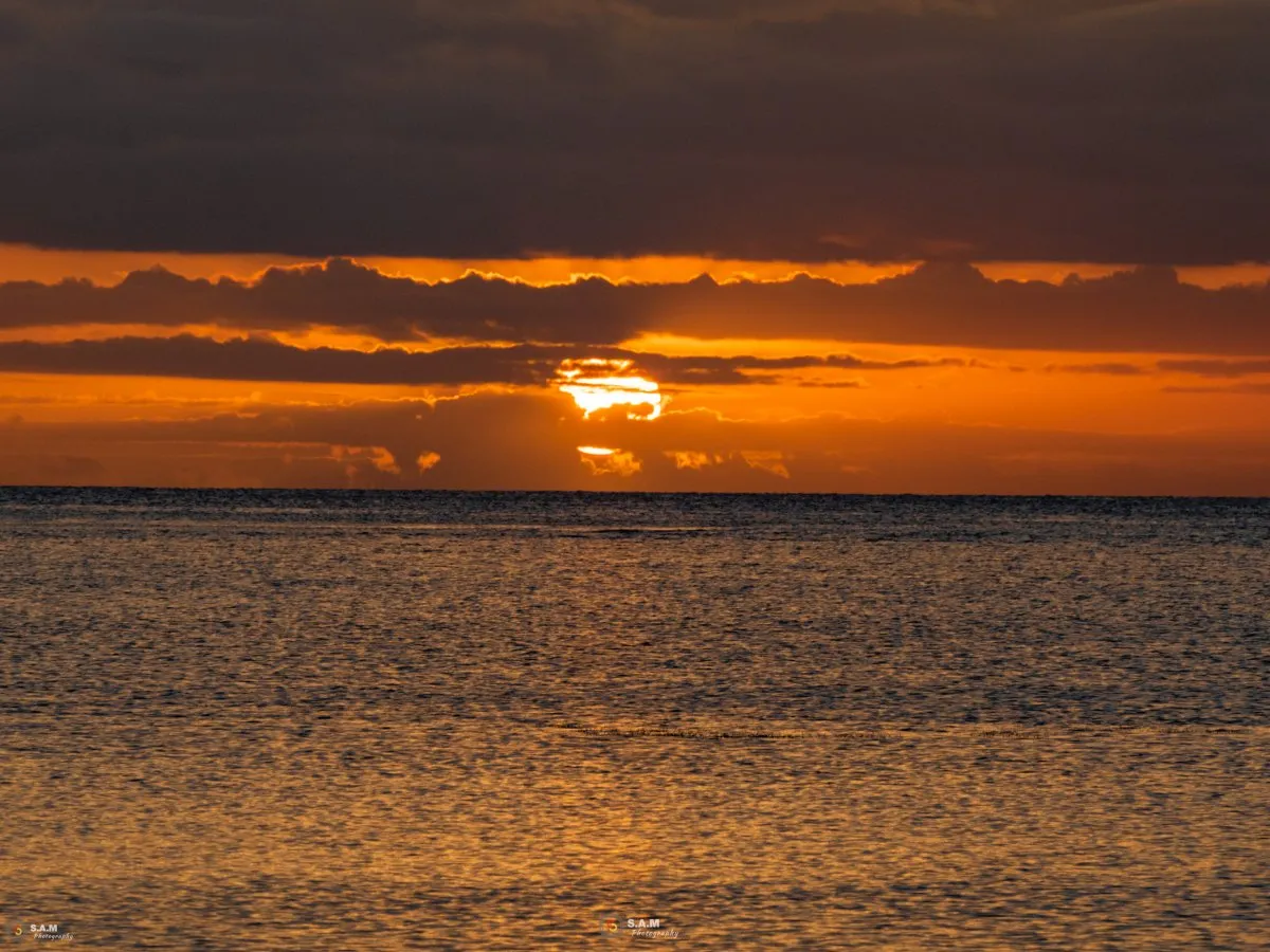 Golden sunset behind clouds over the sea at Souillac village in Mauritius