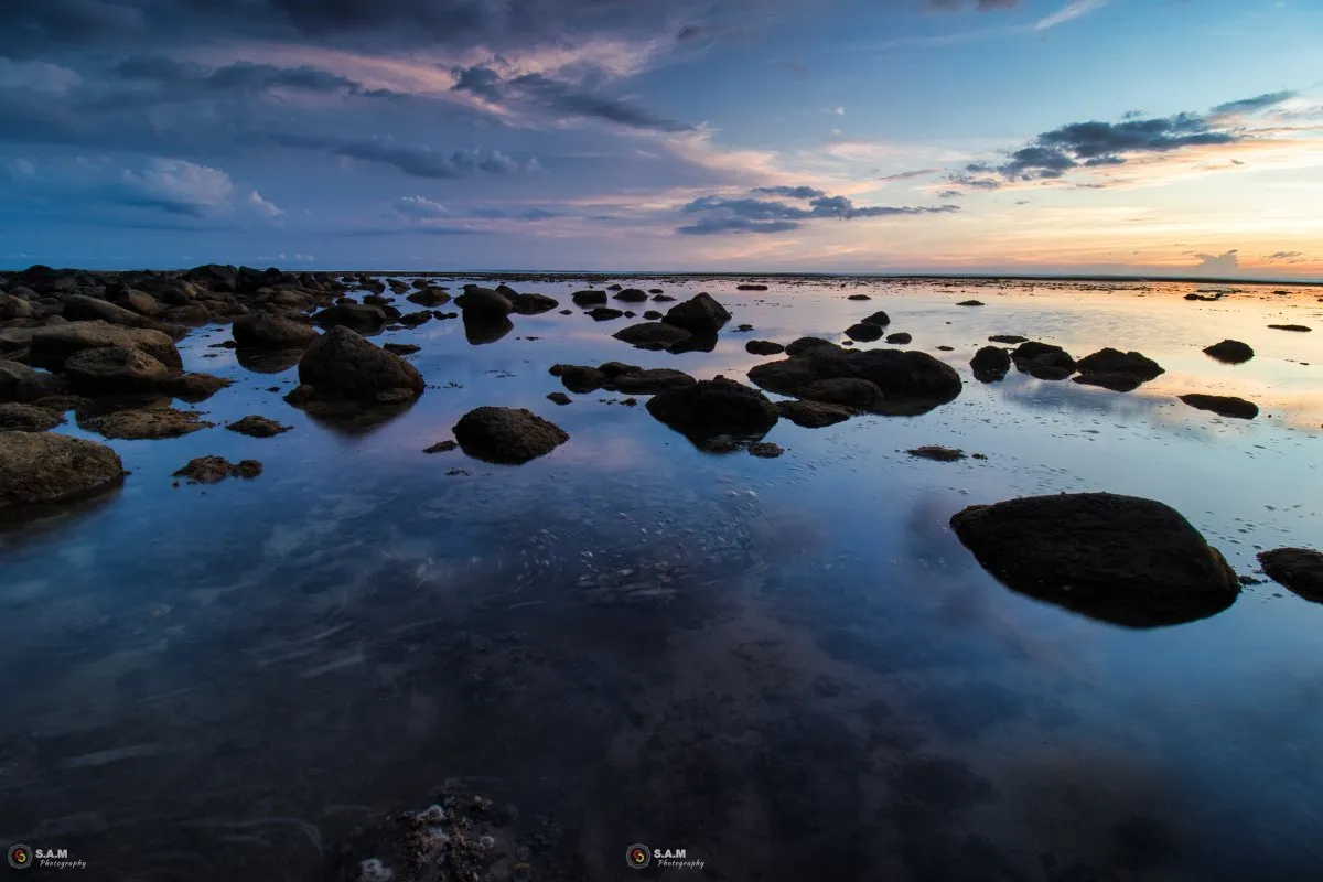 Calm shallow lagoon waters reflecting the blue hour sky at Souillac in Mauritius