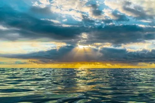 Calm deep blue sea and shy cloudy sunset