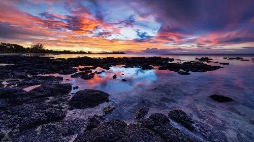 Reflection of sunset at Bain Boeuf rocky beach