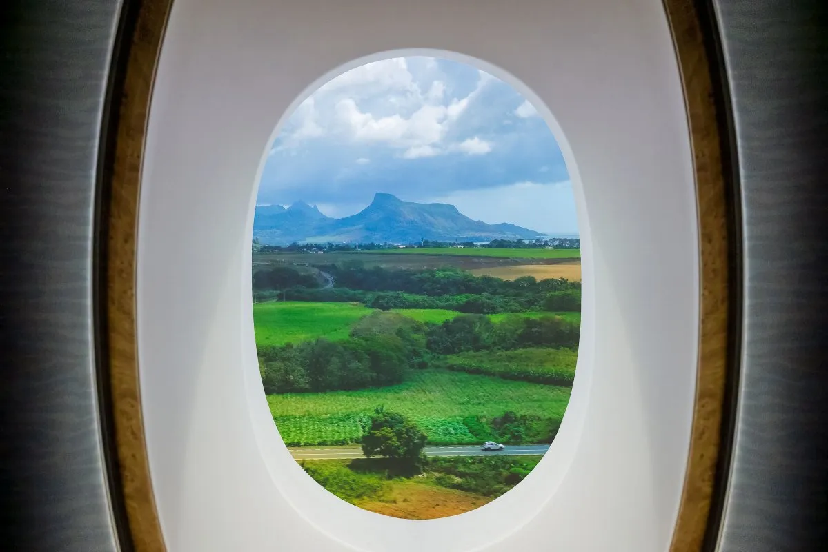 View of Lion mountain and lush forests in Mauritius through an airplane window during landing