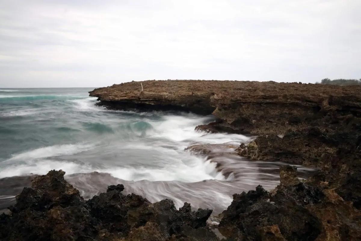 Long exposure photo of waves crashing against sharp rocks at Ilot Sancho, Mauritius