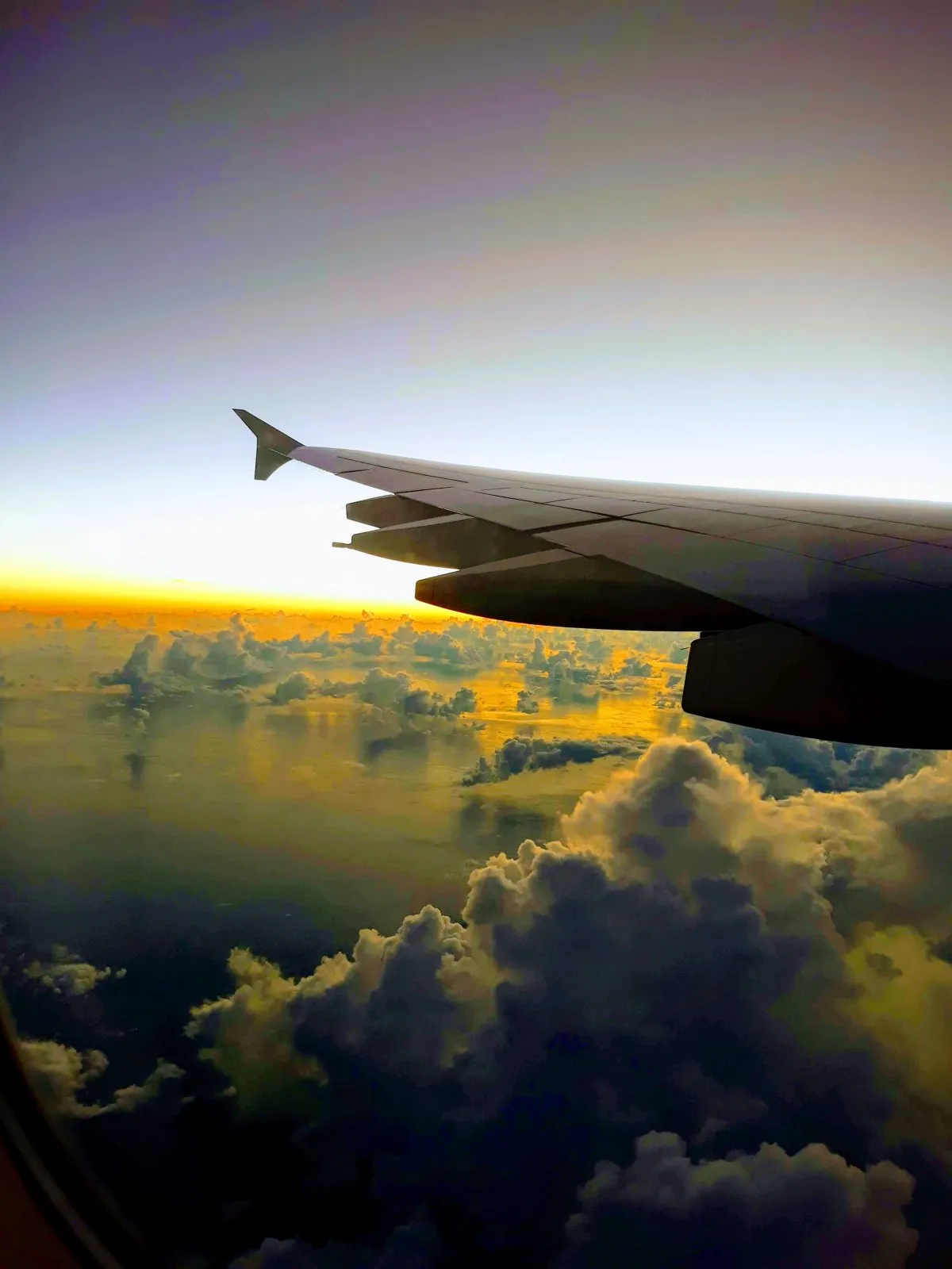 View of a vibrant sunset above clouds from a plane flying over Mauritius